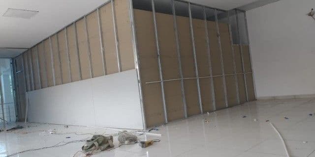 Gypsum board partition wall under construction on a metal stud frame, Chandigarh